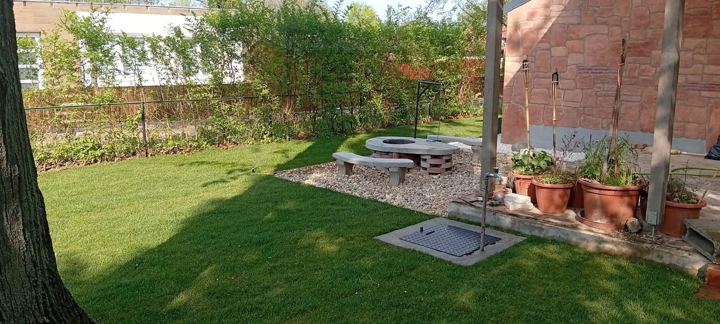Kerti tűzrakóhely kőpadokkal, gondozott gyepben